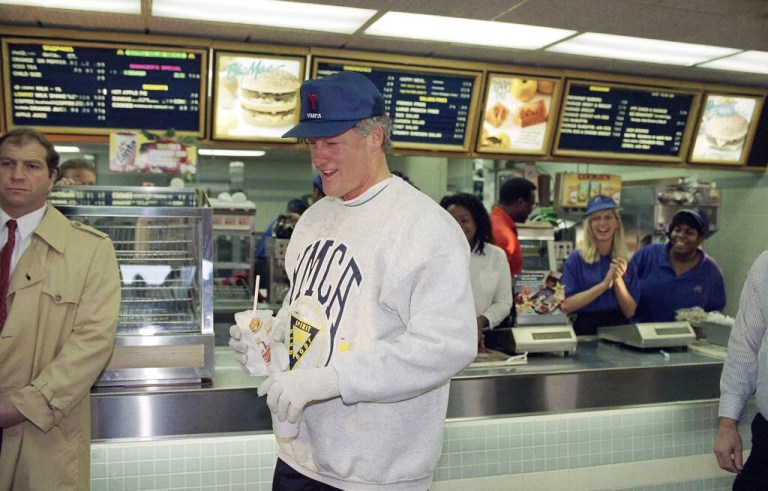 With a cup of coffee and a cold drink in his hands, former President Bill Clinton leaves a local McDonald's restaurant in downtown Little Rock, Arkansas, Jan. 13, 1993. The fast-food establishment is one of Clinton's usual stops during his morning jogs.