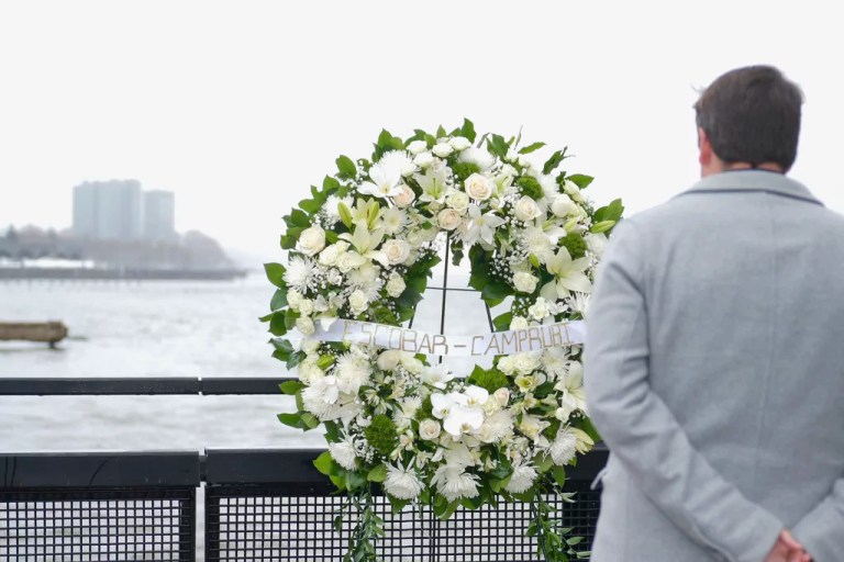 Joan Camprubí Montal, a family member of five of the victims who died in the Hudson River helicopter crash, looks at a memorial wreath on Saturday, April 12, 2025 in New York.