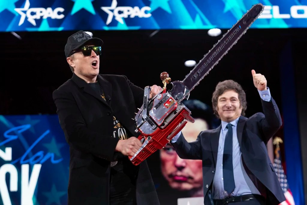 Elon Musk holds a chainsaw handed to him by Argentine President Javier Milei, behind, at the Conservative Political Action Conference (CPAC) in Oxon Hill, Maryland, Feb. 20, 2025. (AP Photo/Jose Luis Magana)