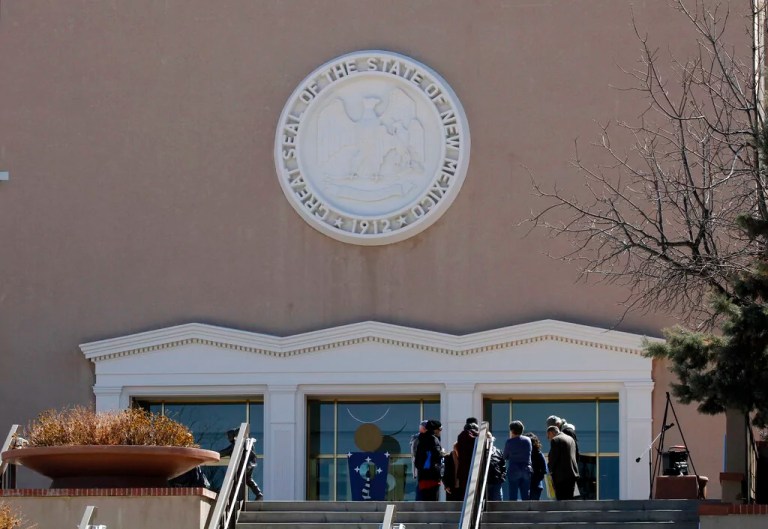 People gather outside the state capitol building, Tuesday, March 30, 2021, in Santa Fe, New Mexico.