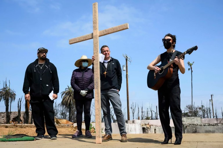 Carli Wright, right, plays music for a church prayer during a Cross Walk event by the Community United Methodist Church of the Pacific Palisades, Friday, April 18, 2025, in the Pacific Palisades area of Los Angeles.
