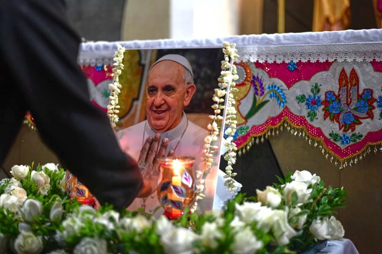 An Indian Catholic nun touches a portrait of Pope Francis after a prayer meeting in Kochi, India, Monday, April 21, 2025, following the Vatican's announcement of his death.