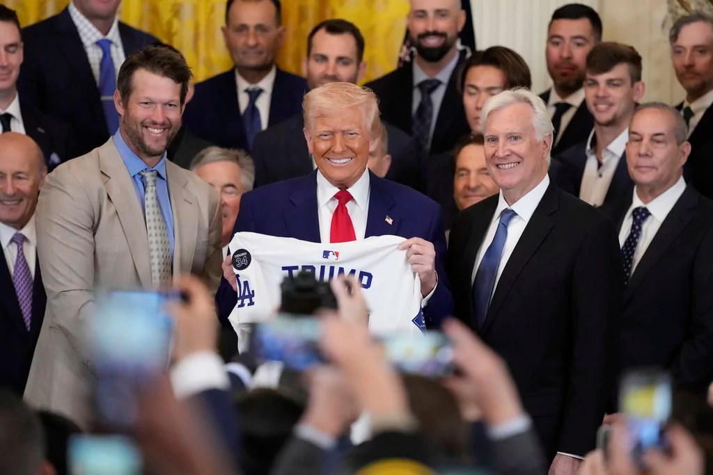 Los Angeles Dodgers' Clayton Kershaw, left, and owner Mark Walter, right, pose with President Donald Trump, right, during a ceremony to honor the Major League Baseball 2024 World Series Champion team in the East Room of the White House, Monday, April 7, 2025, in Washington.
