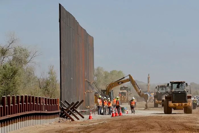 Government contractors erect a section of the Pentagon-funded border wall along the Colorado River, Sept. 10, 2019, in Yuma, Arizona.
