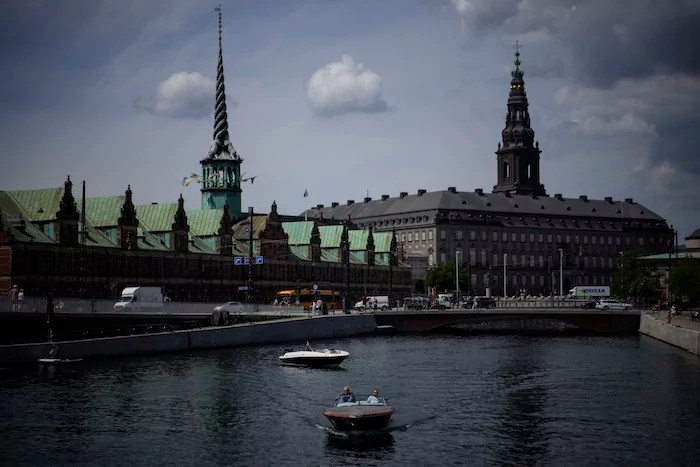 A boat wades through the Nyhavn river in Copenhagen, Denmark