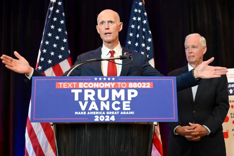 Sen. Rick Scott (R-FL) speaks as Sen. Ron Johnson (R-WI) looks on during a news conference about the Democratic National Convention, Monday, Aug. 19, 2024, in Chicago.