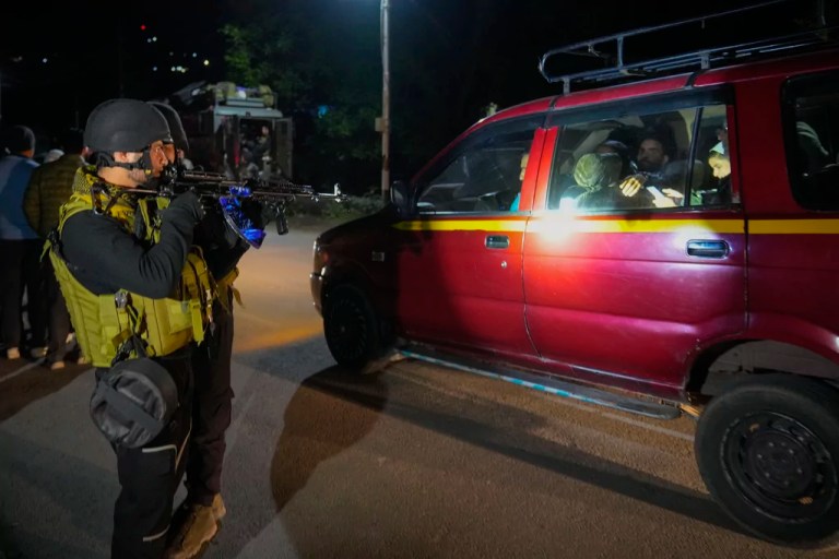 Indian police officers stand guard near Pahalgam in south Kashmir after assailants indiscriminately opened fired at tourists visiting Pahalgam, Indian controlled Kashmir, Tuesday, April 22, 2025.