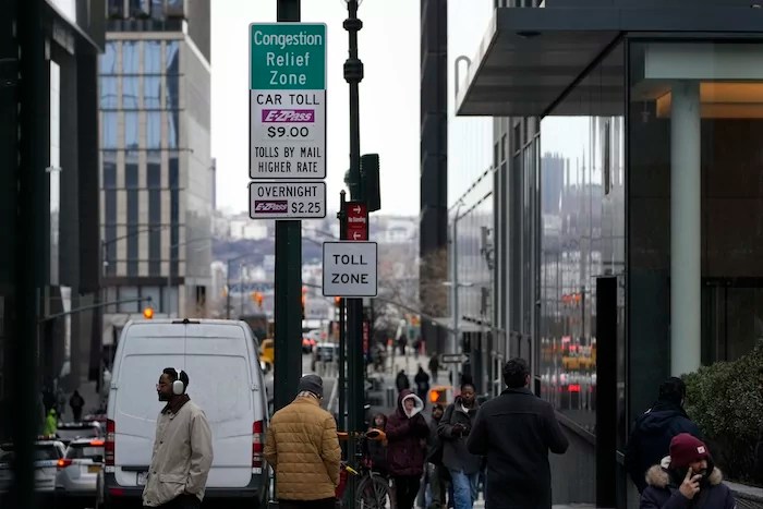 Signs advising drivers of congestion pricing tolls are displayed near the exit of the Lincoln Tunnel in New York, Wednesday, Feb. 19, 2025.