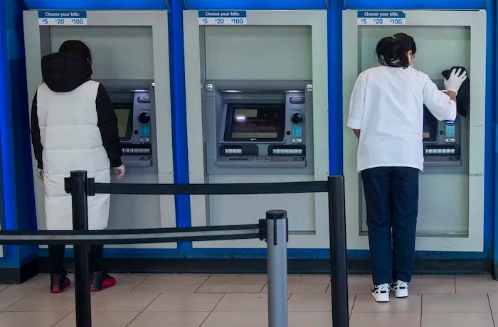 A customer makes a transaction at a bank of automatic teller machines in the Queens borough of New York