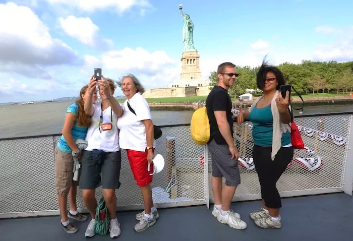 Visitors to the Statue of Liberty take photos as they arrive on the first tourist ferry to leave Manhattan, Thursday, July 4, 2013, in New York.