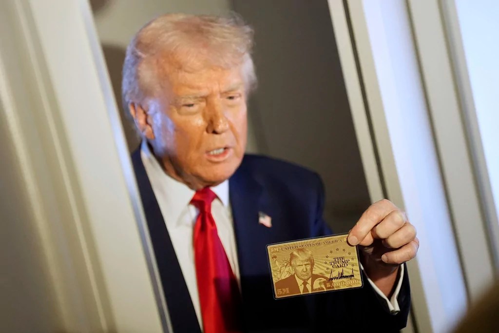 President Donald Trump holds up the $5 million gold card as he speaks to reporters while in flight on board Air Force One, en route to Miami, Thursday, April 3, 2025.