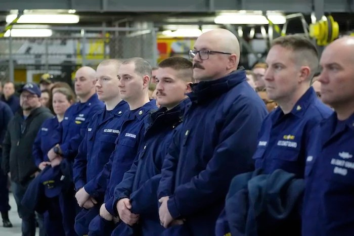 Members of the U.S. Coast Guard listen as Homeland Security Secretary Kristi Noem speaks during a tour of U.S. Coast Guard Air Station Kodiak, Monday, March 17, 2025, in Kodiak, Alaska