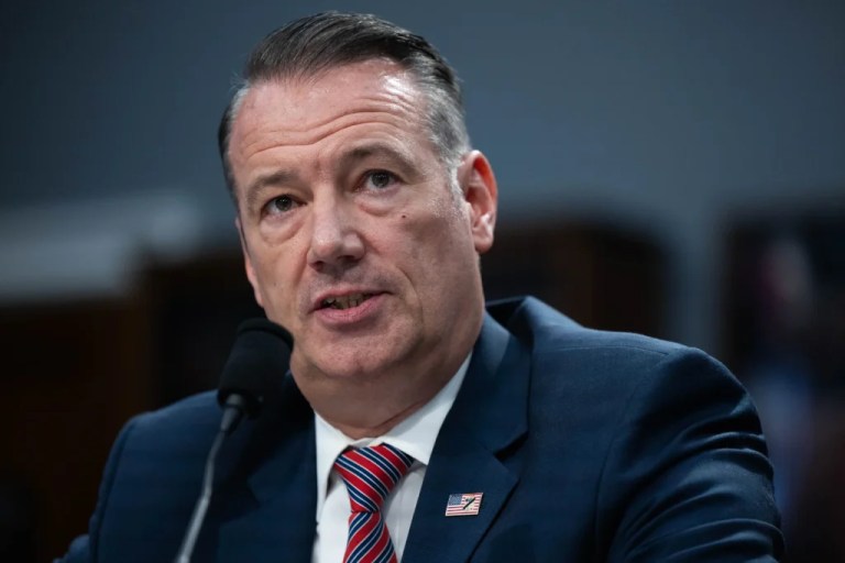 Todd Lyons, acting director for Immigration and Customs Enforcement, appears before a judge with a microphone near him speaking.