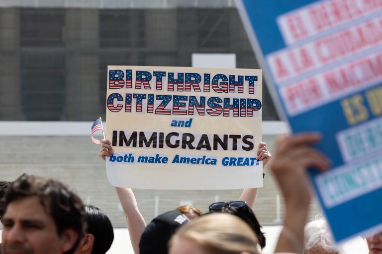 Protesters stand outside the Supreme Court, May 14, 2025, in protest of President Donald Trump's order to curtail birthright citizenship.