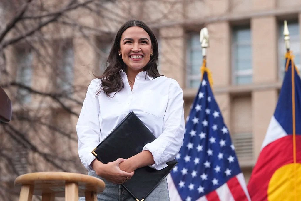 Rep. Alexandria Ocasio-Cortez, D-N.Y., smiles after speaking during a stop of their "Fighting Oligarchy" tour that filled Civic Center Park, Friday, March 21, 2025, in Denver. 