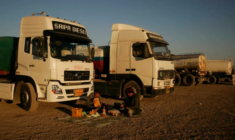 Afghan oil tanker drivers eat in front their vehicles near the Afghan-Iran border at Islam Qala on the outskirts of Herat, west of Kabul, Afghanistan, in the evening of Tuesday, Jan. 4, 2011.