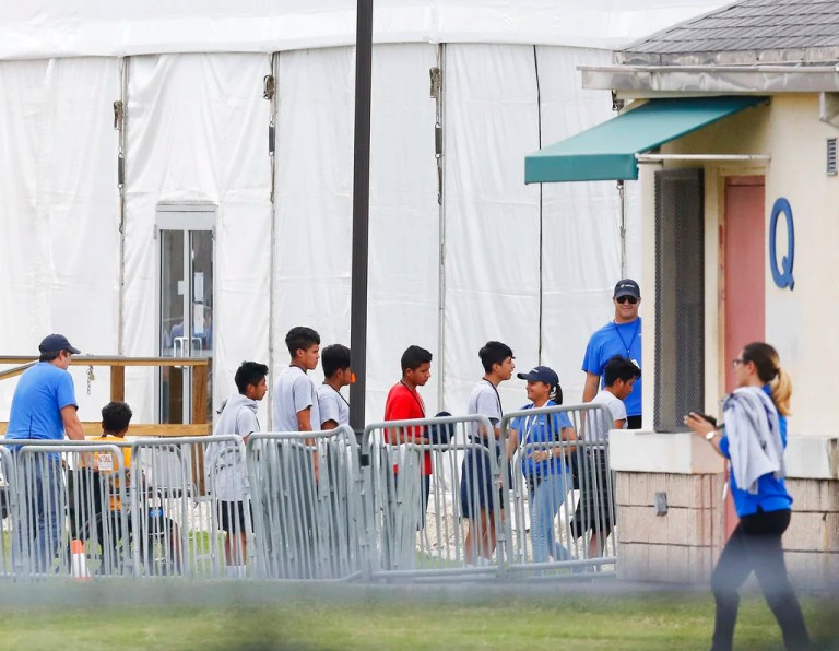 In this June 20, 2018, file photo, immigrant children walk in a line outside the Homestead Temporary Shelter for Unaccompanied Children, a former Job Corps site that now houses them in Homestead, Florida. The landmark court case that has provided the framework for how the government can detain immigrant children has been cited by both sides of the debate over the separation of families at the border. The 1997 settlement known as the Flores agreement has been litigated off and on for the past 33 years and is a crucial piece of the puzzle for the administration's immigration enforcement policies.