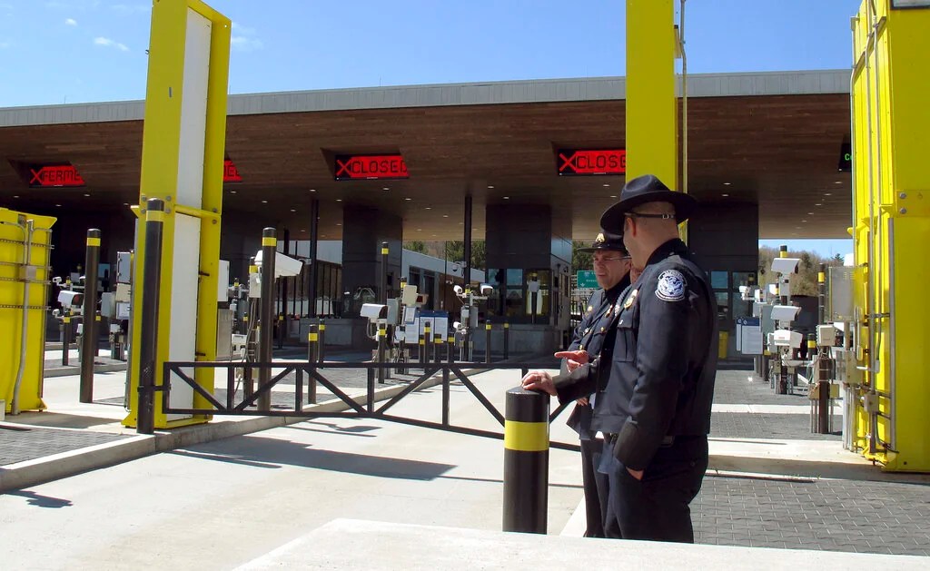 In this May 8, 2019 photo, U.S. Customs and Border Protection officials stand at the new border crossing facility on the U.S.-Canadian border in Derby Line, Vt.   Court documents say federal agents seized almost 370 pounds (166.6 kilos) of cocaine that was hidden in a truck that was preparing to enter Canada at the Derby Line border crossing on Dec. 7.  (AP Photo/Wilson Ring, File)