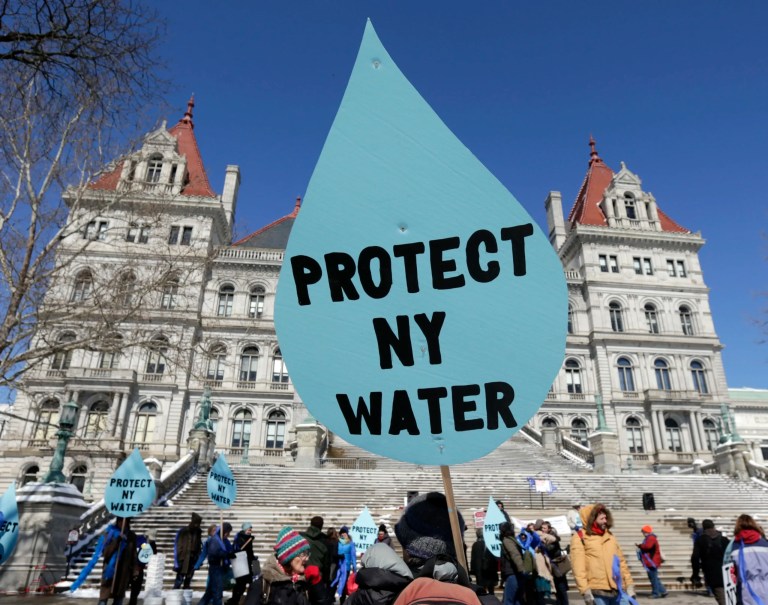 In this April 5, 2016 file photo, a man carries a sign before a rally opposing the Constitution Pipeline outside the state Capitol in Albany, New York. The nearly $1 billion Constitution Pipeline project that was designed to bring natural gas from Pennsylvania's shale gas fields to metropolitan New York and New England has been abandoned after years of legal regulatory challenges made it economically unfeasible, according to a statement Monday from a spokeswoman for project partner Duke Energy said Monday, Feb. 24, 2020.