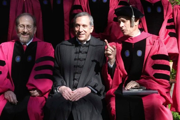 Harvard University Provost Alan Garber, left, Harvard President Lawrence Bacow, center, and actor Tom Hanks, right, speak while sitting for a photograph before joining a procession though Harvard Yard at the start of Harvard University commencement exercises, Thursday, May 25, 2023, on the schools campus, in Cambridge, Massachusetts.