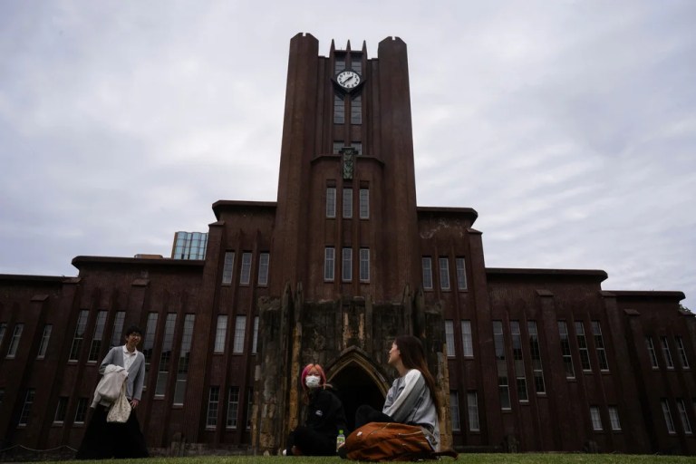 People sit outside the Yasuda Auditorium at the University of Tokyo, Tuesday, May 27, 2025.