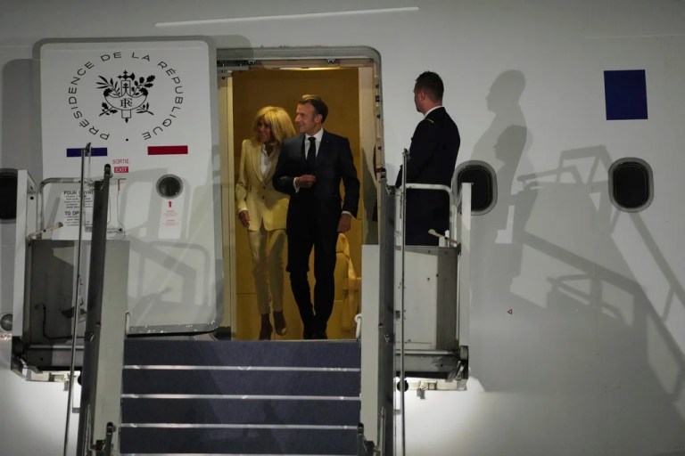French President Emmanuel Macron and his wife Brigitte Macron disembark an aircraft.