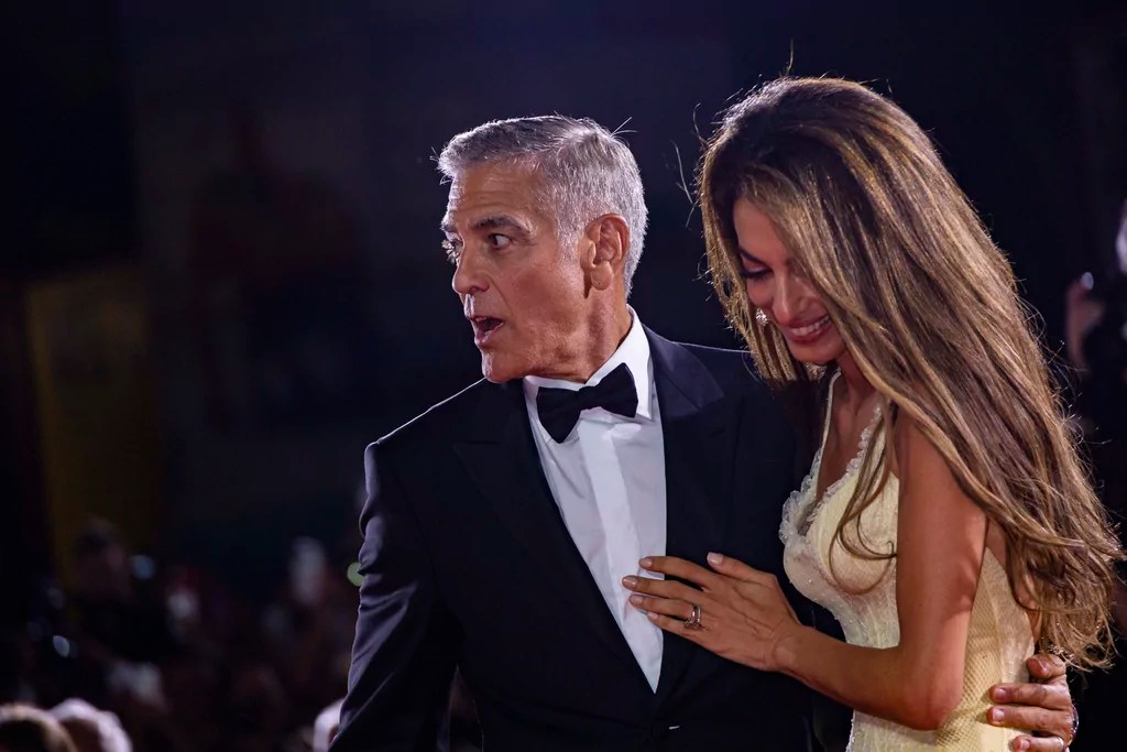 Amal Clooney, right, and George Clooney pose for photographers upon arrival for the premiere of the film 'Wolfs' during the 81st edition of the Venice Film Festival in Venice, Italy, on Sunday, Sept. 1, 2024. 