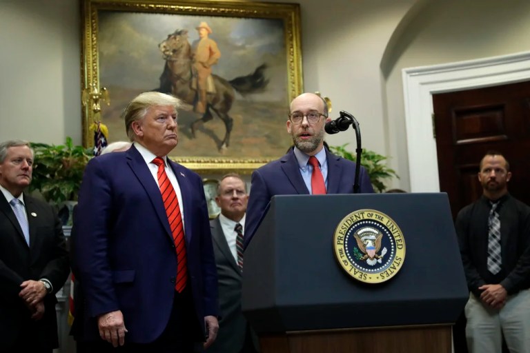 President Donald Trump listens as acting director of the Office of Management and Budget Russ Vought speaks during an event on 