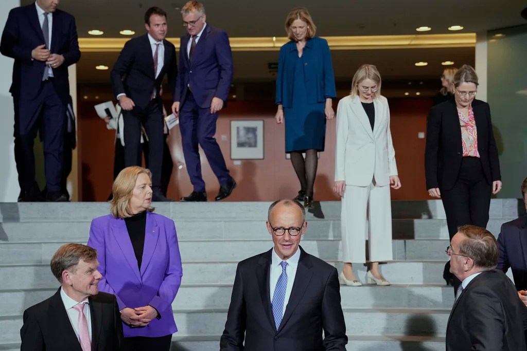 Newly-elected German Chancellor Friedrich Merz, center, and members of the new cabinet arrive for a group photo after the first government cabinet meeting, at the chancellery in Berlin, late Tuesday, May 6, 2025.