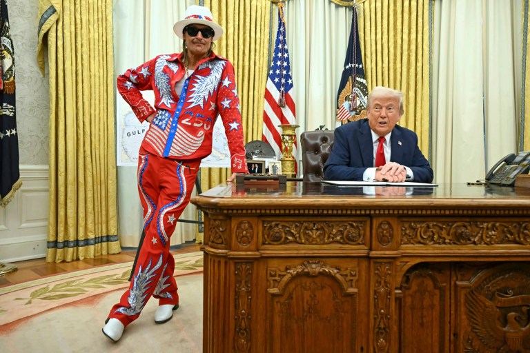 President Donald Trump speaks to reporters before signing an executive order in the Oval Office of the White House in Washington, Monday, March 31, 2025, as Kid Rock listens.