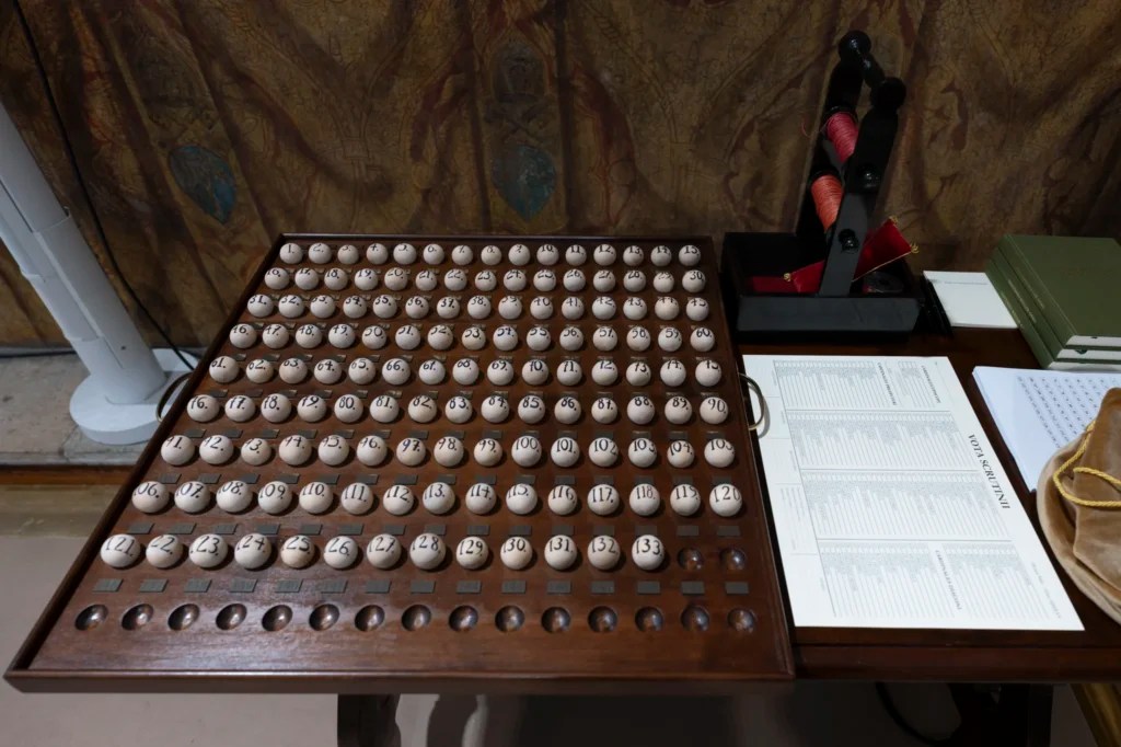 This photo, released by the Holy See's press office, shows the numbered balls and tallying form that will be used to track each cardinal's participation during the voting process of the conclave. All ballots will be pierced by a needle and held together on the nearby spool of red thread to prevent tampering.