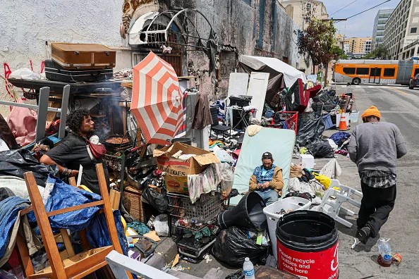 Gov. Gavin Newsom plans to escalate California's push to eradicate homeless encampments on Monday, calling on hundreds of cities, towns and counties to effectively ban tent camps on sidewalks, bike paths, parklands and other types of public property. Pamela Morales, left, cooks a meal at an encampment on Garland Ave, downtown. Morales said they have lived here for nearly four months.