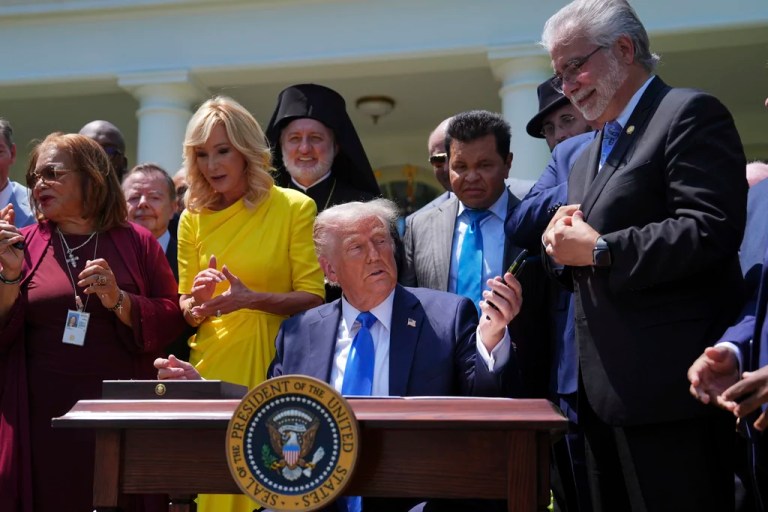 President Donald Trump hands pens used to sign an executive order establishing the Religious Liberty Commission, to religious leaders during a National Day of Prayer event in the Rose Garden of the White House, Thursday, May 1, 2025, in Washington.