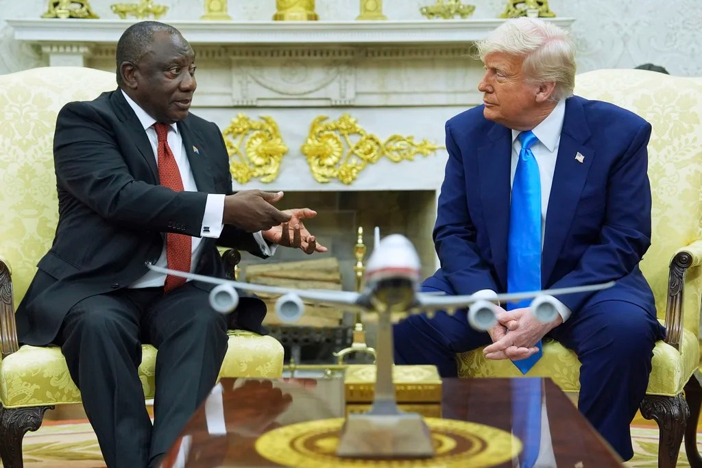President Donald Trump shows documents as he meets South Africa's President Cyril Ramaphosa in the Oval Office of the White House, Wednesday, May 21, 2025, in Washington. (AP Photo/Evan Vucci)