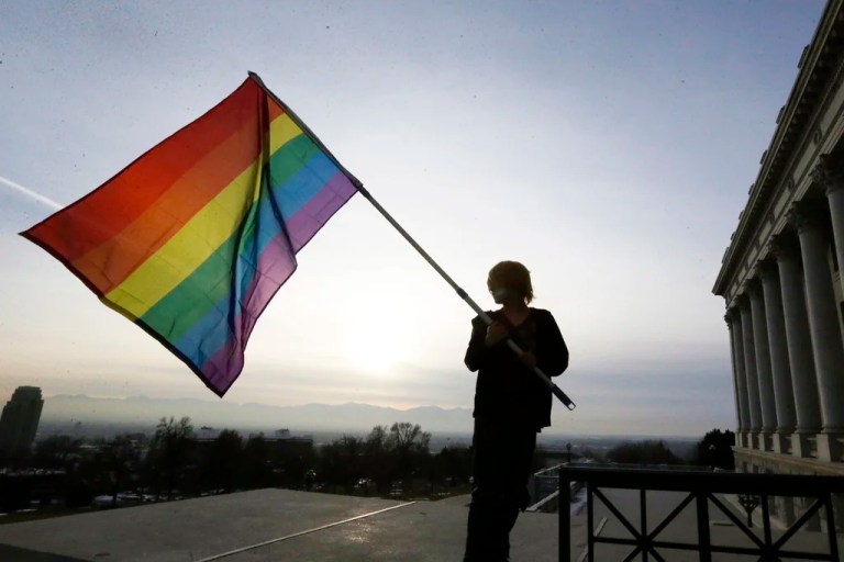 Corbin Aoyagi, a supporter of gay marriage, waves a rainbow flag during a rally at the Utah State Capitol on Jan. 28, 2014, in Salt Lake City. Utah teachers will be free to display LGBT pride flags and other social, political or religious imagery after the state House blocked a bill Monday, Feb. 26, 2024, that would have banned teachers from using their position to promote or disparage certain beliefs.