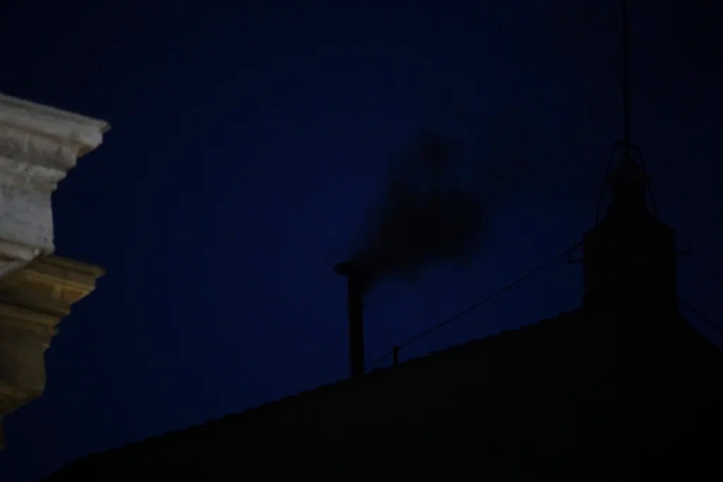 Black smoke billows from the chimney of the Sistine Chapel during the conclave to elect a new pope, at the Vatican, Wednesday, May 7, 2025.