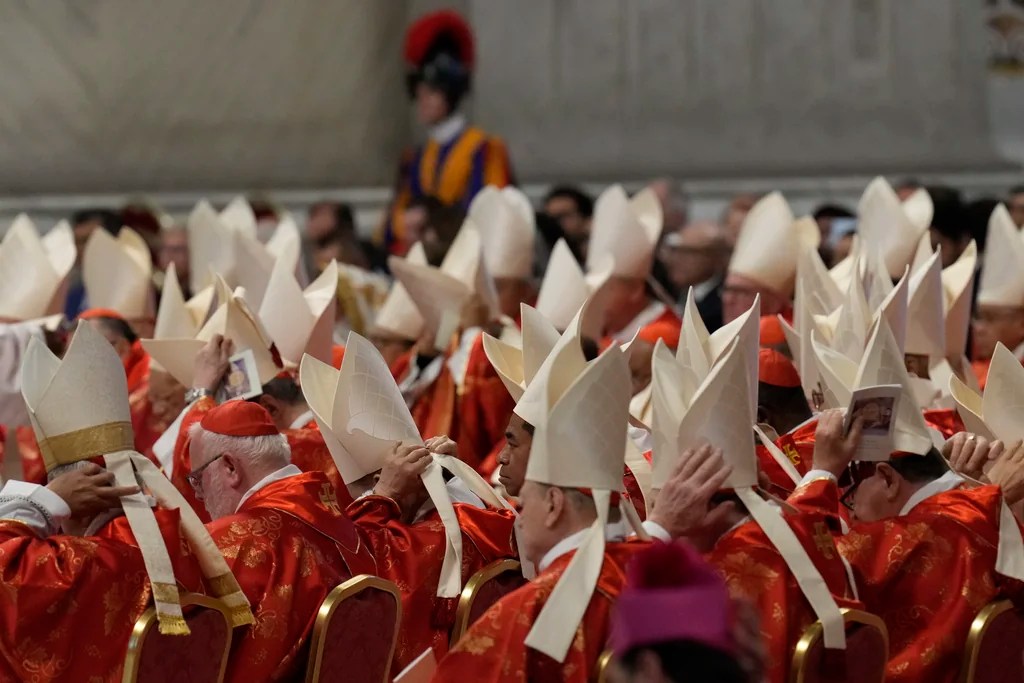 Cardinals adjust their mitre hats during a final Mass celebrated by cardinals inside St. Peter's Basilica before the conclave to elect a new pope, at the Vatican, Wednesday, May 7, 2025.