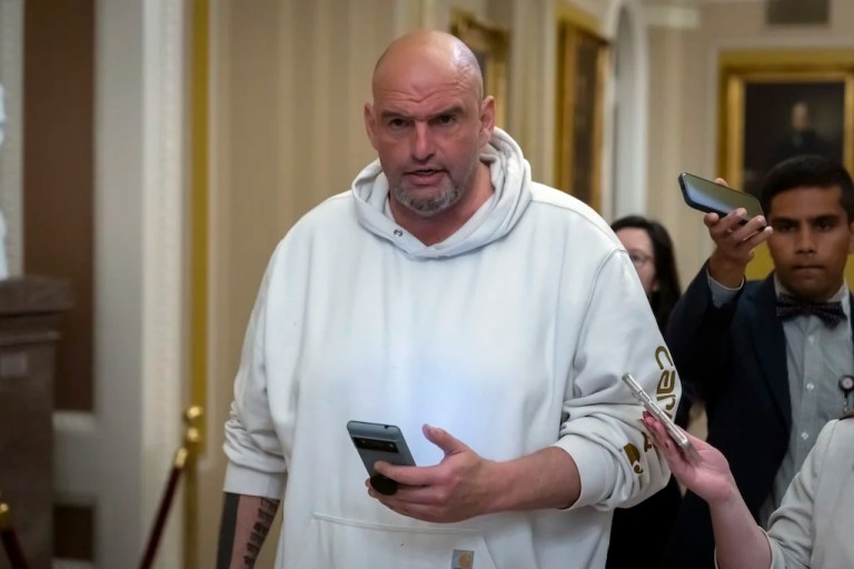 Sen. John Fetterman, D-Pa., speaks to reporters as he walks near the Senate chamber at the Capitol in Washington, Friday, March 14, 2025. (AP Photo/Ben Curtis)