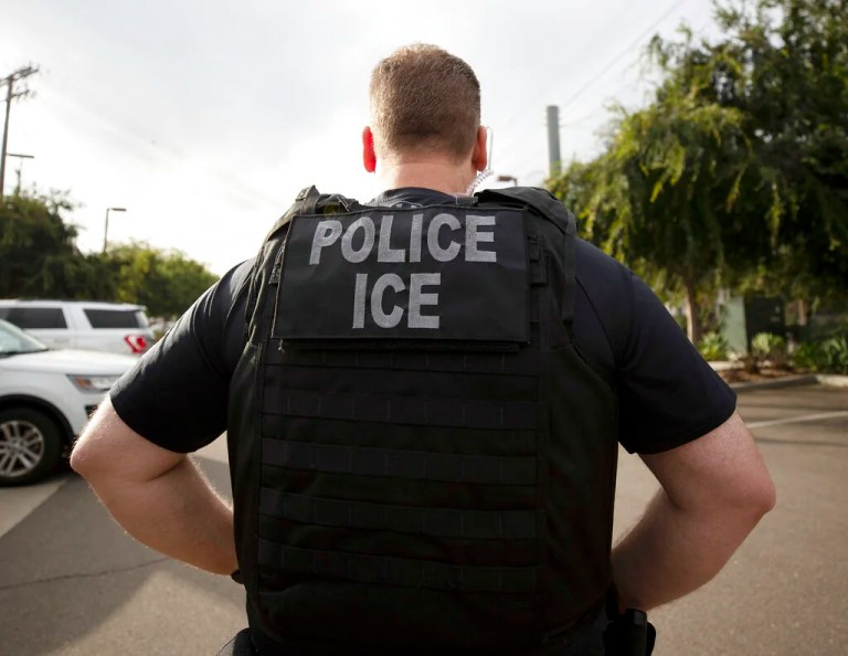 The vest of an agent walking away from the direction of the camera says 