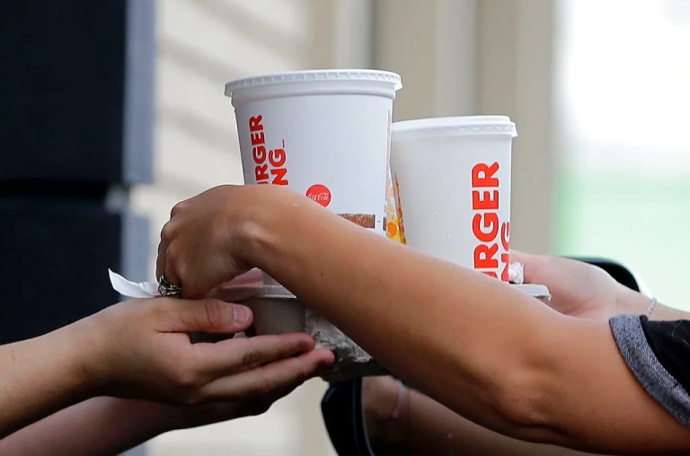 In this Monday, Oct. 31, 2016, photo, a customer picks up his order at a Burger King drive-thru window in Miami. U.S. services companies saw their growth rate taper off in March 2017, as hiring and business activity remained positive but dipped relative to February. Fifteen services industries reported growth in March, including retailers, real estate and food services. But three sectors contracted: information, education and scientific and technical services. (AP Photo/Alan Diaz)