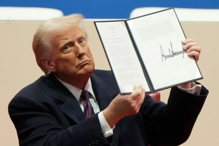FILE - President Donald Trump holds up an executive order after signing it at an indoor Presidential Inauguration parade event in Washington, Jan. 20, 2025. (AP Photo/Matt Rourke, File)
