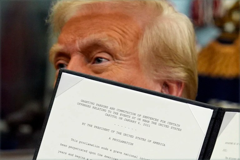 President Donald Trump signs an executive order pardoning about 1,500 defendants charged in the Jan. 6 attack on the U.S. Capitol in the Oval Office of the White House, Monday, Jan. 20, 2025, in Washington.