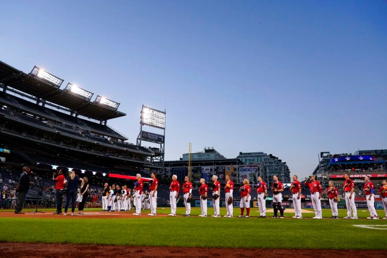 Democrats and Republicans stand during the national anthem before the Congressional baseball game at Nationals Park