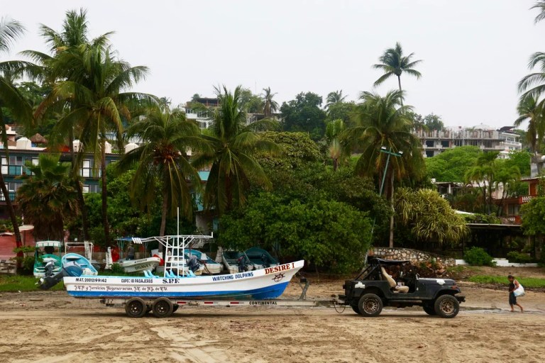 A fisherman moves his boat before the arrival of Hurricane Erick in Puerto Escondido, Oaxaca state, Mexico, Wednesday, June 18, 2025