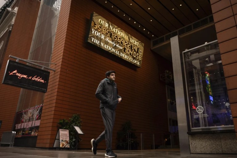 A person walks past the National Debt Clock.