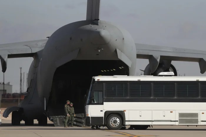 FILE - A military aircraft waits for migrants to board from a bus at Fort Bliss in El Paso, Tx., Thursday, Jan. 30, 2025, before deporting them to Guatemala. (AP Photo/Christian Chavez, File)