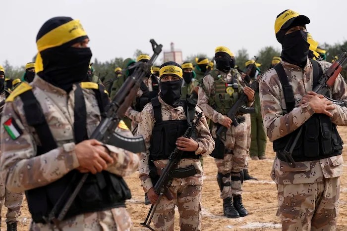 Masked Palestinian militants from the Al Aqsa Martyrs' Brigade, a militia linked to the Fatah movement, hold their weapons during a military show marking the 58th anniversary of the Fatah movement's founding, at their military training camp in Khan Younis, southern Gaza Strip, Sunday, Jan. 1, 2023.