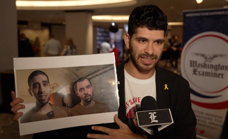 Ilay David holds up a screen grab from a Hamas propaganda video showing his brother, Evyatar, gaunt and pleading for his life.