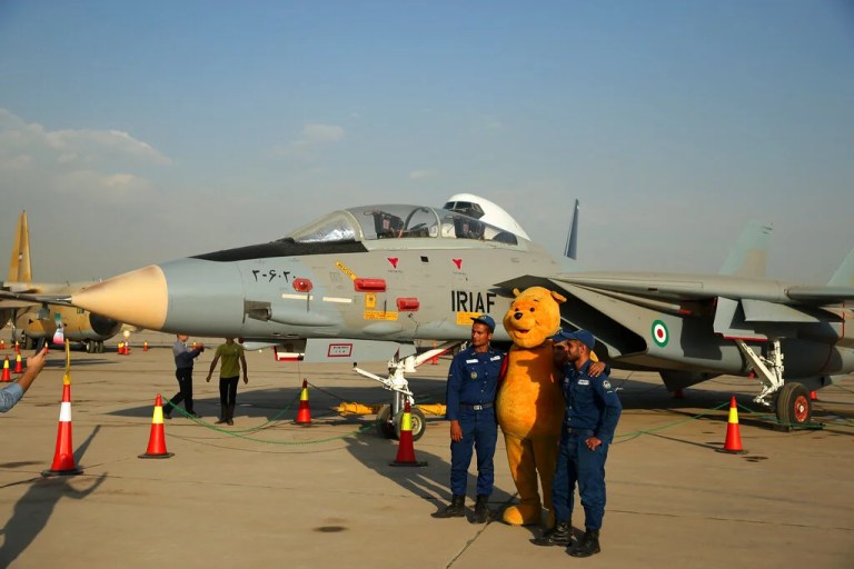 Iranian soldiers take a picture with a Winnie the Pooh character next to a F-14 fighter jet in an exhibition of achievements and equipment of Iran's air force in Tehran, Iran, Wednesday, Sept. 23, 2015. Iran's semi-official Tasnim news agency is reporting that the country's army has unveiled a new locally-made reconnaissance drone that can stay aloft for up to six hours. The Tasnim report Wednesday says the drone dubbed Mohajem 92 has a range of 500 kilometers (310 miles) with a maximum speed of 200 kph (125 mph).