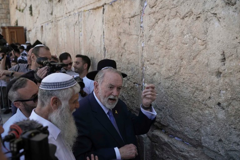 The US ambassador to Israel Mike Huckabee holds a note given to him from US President Donald Trump to be placed in the cracks of the Western Wall, the holiest site where Jews can pray, in the Old City of Jerusalem, Friday, April 18, 2025.